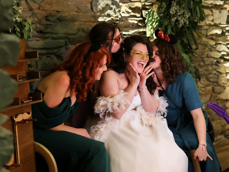 Bride Enjoying Photohoof Booth Bride and wedding guests laughing inside Photohoof photo booth during evening reception