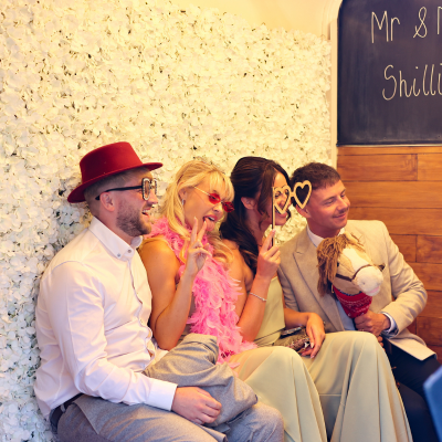 Wedding guests enjoying Photohoof horse box photo booth with props at a Lake District wedding