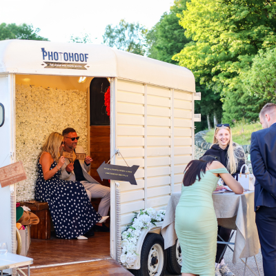 Photohoof horse box photo booth at outdoor wedding venue with guests enjoying the booth